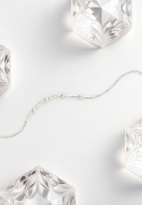 Collana di perline color argento con accenti rotondi e fasetatti alternati, su uno sfondo bianco con blocchi di cristallo decorativi.