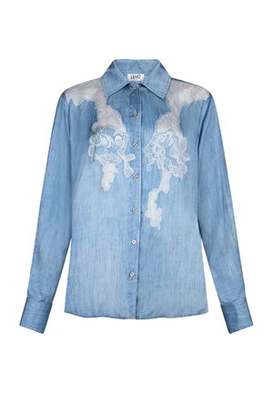 Gaiši zils džinsu krekls ar garām piedurknēm, pogām priekšpusē un baltām ziedu mežģīņu aplikācijām uz pleciem un krūtīm.