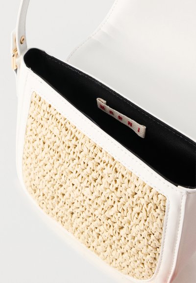 Λευκή τσάντα ώμου με πλεγμένο μπεζ μπροστινό πάνελ, μαύρη εσωτερική επένδυση και ετικέτα υφάσματος με μάρκα στο εσωτερικ ό.