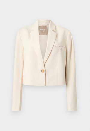 Blazer crem scurtat cu un singur nasture frontal, rever cu crestături și un mic batiste pliat în buzunarul de la piept.