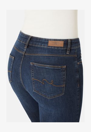 Dunkelblaue Denim-Jeans mit slim Fit, mit geschwungenen Nähten an den Gesäßtaschen und einem Lederetikett mit Markennamen am Bund.