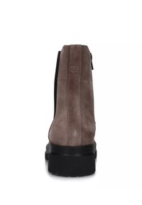 Stivale alla caviglia in suede grigio-marrone con pannelli laterali elasticizzati e suola nera spessa. Presenta dettagli di cucitura discreti e una texture liscia.