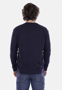 Maglione lavorato a maglia blu navy con maniche lunghe, polsini e vita a coste, texture liscia e un design classico con collo a girocollo.