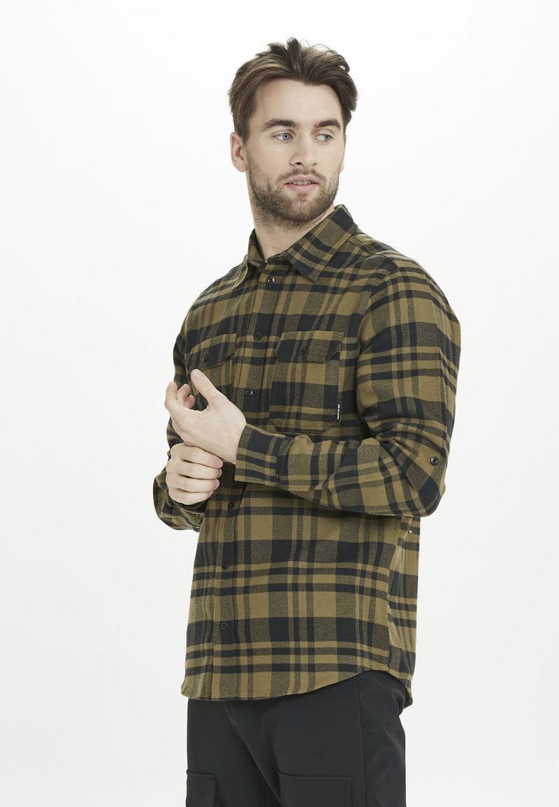 Ruitvormig flanellen shirt in olijfgroen en zwart. Heeft knopen, twee borstzakken en een relaxte pasvorm met verstelbare manchetten. Zachte textuur.