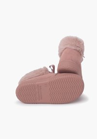 Botas de ante rosa con puño de pelaje sintético esponjoso, suela de goma texturizada y detalle de cinta en la parte trasera. La suela presenta un patrón en zigzag para mayor tracción.