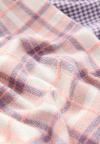 Tessuto morbido con motivo a quadri rosa e lavanda, caratterizzato da accenti bianchi e viola scuro. La texture appare leggermente pelosa e calda.