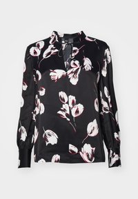 Blouse noire à imprimé floral blanc et rouge, avec un col montant, des manches longues, et une ouverture en goutte d'eau au niveau du cou. Texture de tissu lisse.
