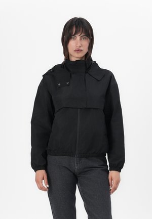 Zwarte cropped jas met een hoge kraag, drukknopen, elastische manchetten en een ritssluiting aan de voorkant. Gemaakt van een glad, lichtgewicht materiaal.