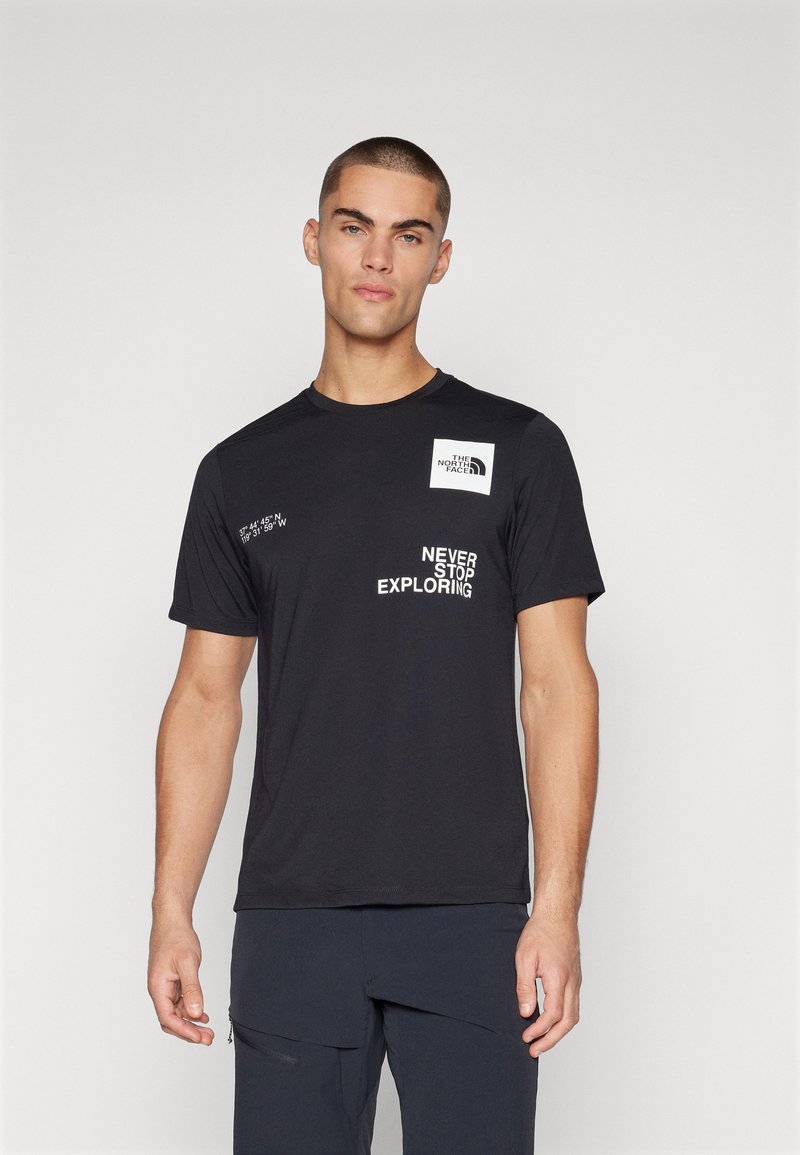 Svart T-skjorte med kort erm som har et hvitt logo-patch på brystet, teksten "NEVER STOP EXPLORING" og geografiske koordinater i hvit skrift.