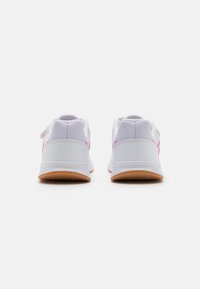 Białe buty sportowe z różowymi akcentami, zaprojektowane z siateczkową cholewką i gumową podeszwą, z wyściełanym kołnierzem i minimalistycznym wzornictwem.