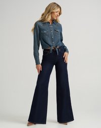 Jeansskjorta med tryckknappar och två bröstfickor, knuten i midjan. Mörkblå utsvängda jeans med hög midja, strukturerad tyg, bärs med beige klackar.