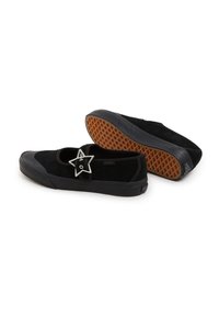 Svarta mockaskor med gummisula, prydda med en stjärnformad silverspänne och en strukturerad insida. Designen är låg och avslappnad.