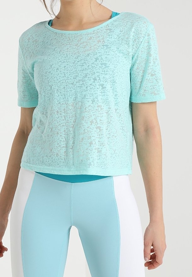 Ljusblå, kortärmad t-shirt i ett semi-genomskinligt texturerat material, med rund halsringning, tillsammans med matchande leggings.