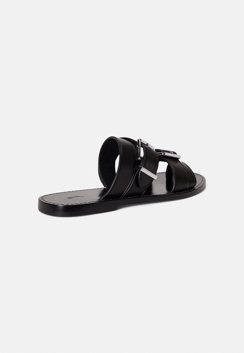 Black leather slide sandal with horizontal straps and a buckle detail. Flat sole, smooth texture, and minimalistic design.