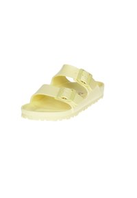 Sandalia deslizante amarilla, casual, hecha de plástico liso. Presenta dos correas ajustables con hebillas de color plateado y una suela texturizada.