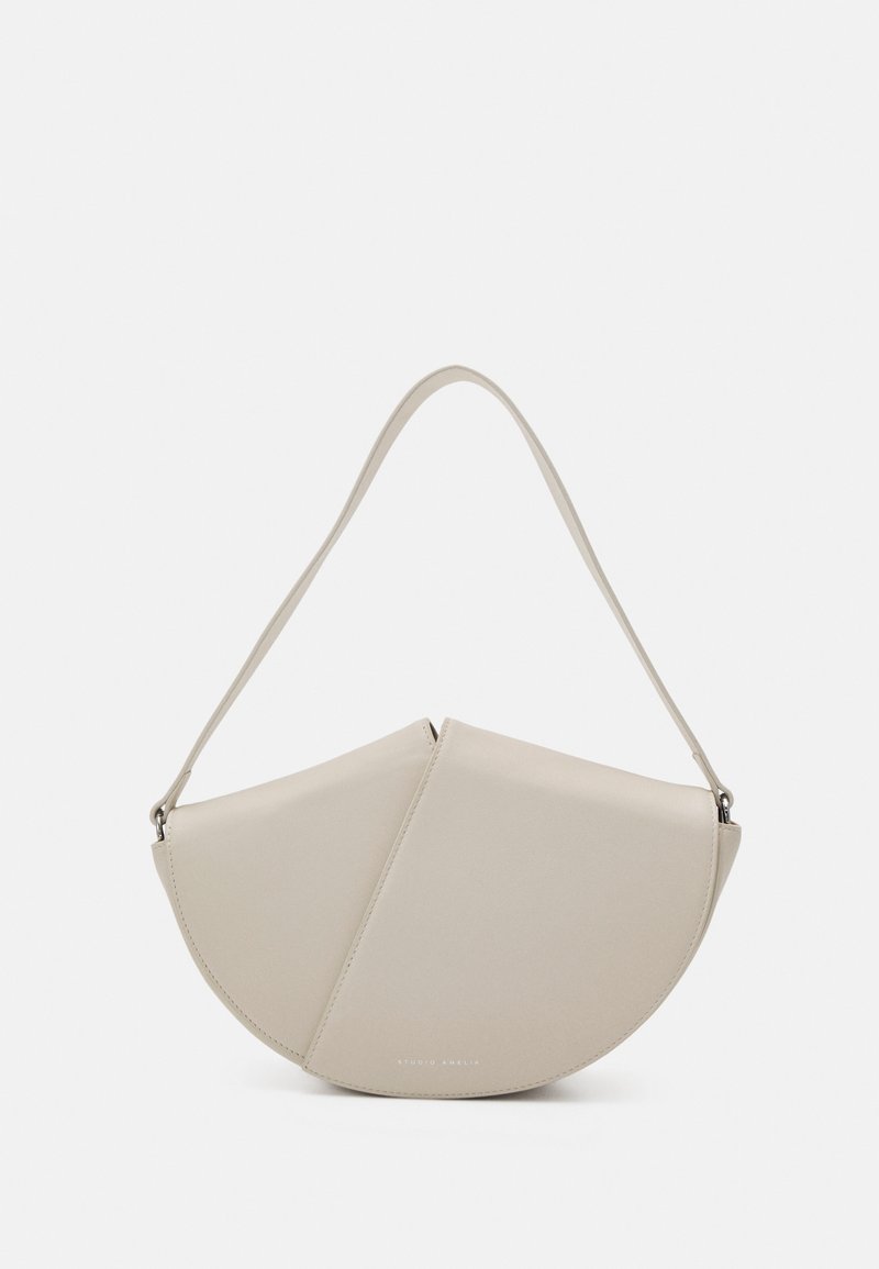 Borsa a tracolla in pelle beige con una forma unica a mezzaluna, texture liscia e una tracolla sottile. Presenta un logo goffrato discreto.