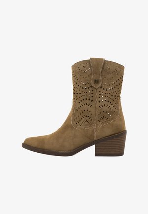 Botín de ante marrón con patrones florales cortados a láser, punta redonda, tacón cuadrado apilado y tirador en la parte superior del caña.