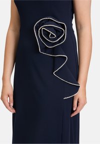 Granatowa sukienka z warstwowym wzorem róż w akcentach z kryształków, wykonana z gładkiego materiału o dopasowanym kroju.