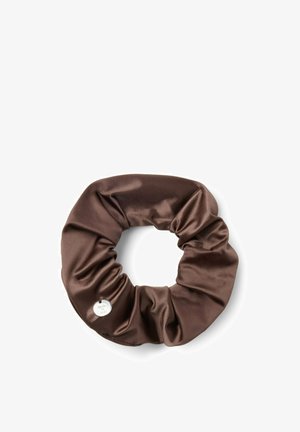 Chouchou en satin marron avec un petit charm en argent rond, sur un fond blanc uni.