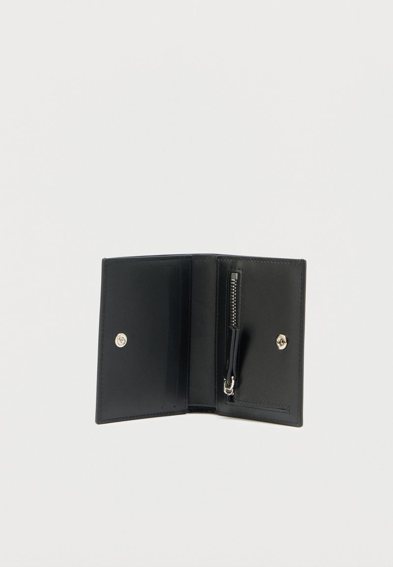 Sort læderpung med lynlåslomme, trykknaplukning og flere kortholdere. Glat tekstur og kompakt design.