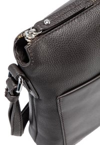 Borsa in pelle marrone scuro con superficie texturizzata, dotata di una cerniera metallica, tracolla regolabile e tasca frontale.