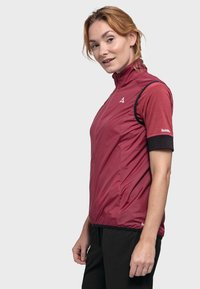 Rote Kurzarmjacke mit hohem Kragen, strukturiertem Stoff und schwarzen Ärmelakzenten. Verfügt über ein Logo auf der Brust und eine schlanke Passform.