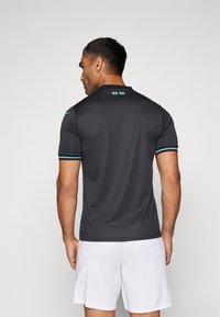 Camiseta atlética de manga corta, negra, con detalles en turquesa en las mangas y el cuello. Textura suave, diseño ajustado, funcional para el deporte.