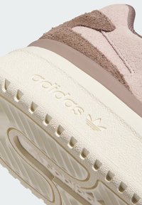 Roze i smeđe suède patike s teksturiranom bijelom gumom, s ugraviranim logotipima i dizajnom srednjeg sloja s određenom potporom.