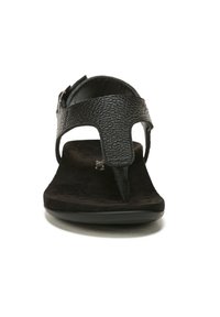 Zwarte teenslippers met een gestructureerde leren bovenkant, een zachte suede voetbed en een slanke platte zool, met een decoratief bandontwerp.