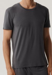 Czarna szara koszulka z krótkim rękawem i okrągłym dekoltem, wykonana z gładkiego materiału, z minimalną ilością szwów i luźnym krojem.