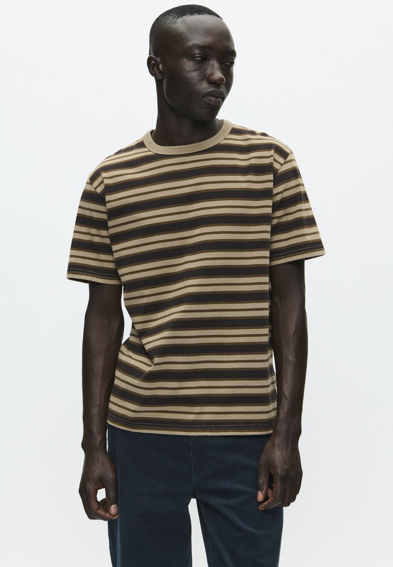 Stripet t-shirt lavet af blødt stof med vandrette brune, beige og creme striber. Har en ribbet halsudskæring og korte ærmer.