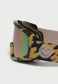 Mustakehyksiset laskettelulasit, joissa on keltainen maastokuvioinen hihna ja peilimäinen linssi, joka heijastaa vihreitä ja vaaleanpunaisia sävyjä. Mukana pehmeä pehmuste.