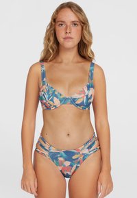 Kvetinový bikini s modrým pozadím a ružovými a zelenými kvetinovými vzormi. Vrchný diel má široké ramienka a štruktúrovaný dizajn; spodný diel má postranné výrezy.