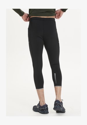 Black compression leggings with a fitted design, featuring two side pockets and reflective accents along the calves. Smooth texture.