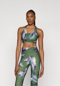 Súprava športovej podprsenky a legín v zelenej farbe s kvetinovým vzorom. Má priliehavý strih, mäkkú látku a strih s priehľadnými ramienkami pre pohodlie a flexibilitu.