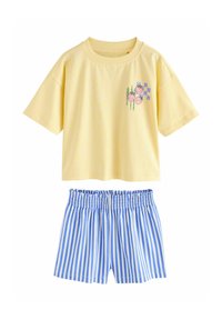 Gul top med korte ærmer med lille lyserød jordbær og blåt kvadratisk motiv, kombineret med blå og hvide shorts med lodrette striber og elastik i taljen.