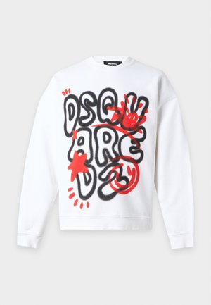 Homme portant un sweat-shirt blanc avec un imprimé style graffiti noir et rouge, un jean bleu, des baskets beiges et une casquette bleu clair sur fond uni.