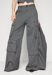 Szare spodnie cargo z szerokimi nogawkami, wyposażone w wiele bocznych kieszeni, z zapięciem na guzik oraz teksturowanym materiałem. Idealne do noszenia na co dzień.