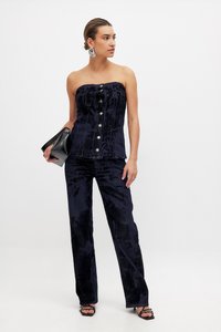 Navy velvet strapless top with front buttons, paired with matching slim trousers. Accessories include a black clutch and silver earrings.