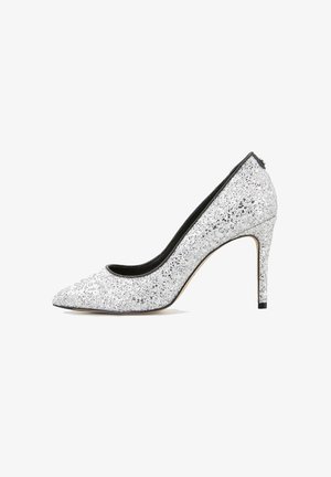 Escarpin à talon haut pailleté argenté avec bout pointu, doublure intérieure noire et talon aiguille fin. Texture lisse avec des accents scintillants.