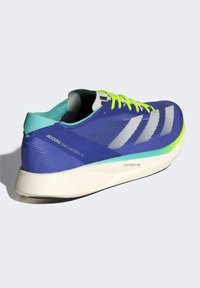 Zapatilla de correr morada con un upper texturizado, rayas blancas y cordones verde neón. Presenta un talón turquesa y una suela crema con "LIGHTSTRIKE PRO."
