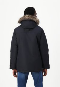 Giacca parka blu navy con cappuccio foderato in pelliccia, zip frontale e dettagli in velcro. Presenta una vestibilità dritta e polsini elasticizzati.