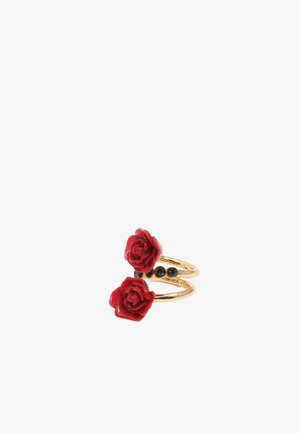 Anillo de doble aro en tono dorado que presenta dos acentos de rosa roja, embellecimientos de piedra negra y bandas lisas. El diseño floral añade un vibrante contraste de color.