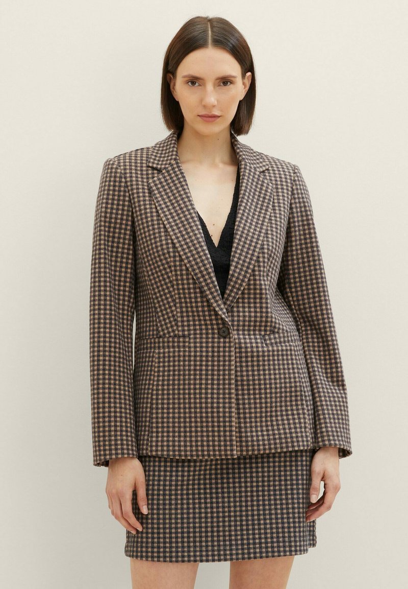 Braun-beige karierter Blazer mit einem knöpfigen Verschluss und Reverskragen, kombiniert mit einem passenden Rock. Strukturiertes Gewebedetail.