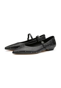 Scarpe flat nere a punta con cinturino alla caviglia e borchie decorative in argento distribuite uniformemente sulla superficie. Materiale in morbida pelle, tacco basso.