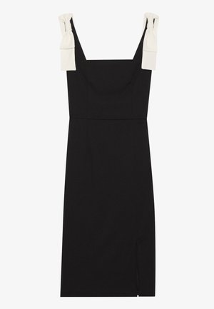 Black dress with a fitted silhouette, square neckline, and white fabric ties on the shoulders. Features a side slit for added detail.