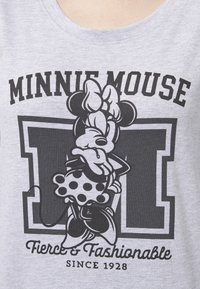 T-shirt in cotone grigio con una grafica nera di Minnie Mouse, decorata con pois e testo che recita "Minnie Mouse Fierce & Fashionable Since 1928."