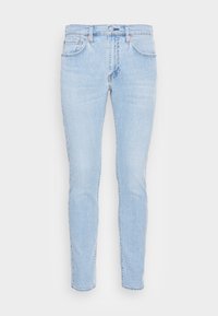 Ljusblå denimjeans med en åtsittande design. Funktioner inkluderar fem fickor, kopparnitar och knäppning med knapp. Texturen är något urblekt.