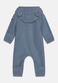Blå fleece-onesie med hette og øreakenter, lange ermer og ankelmansjetter. Myk tekstur og enkel design, egnet for spedbarn.