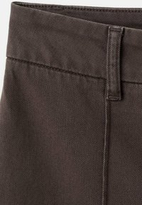 Fascia in tessuto marrone con superficie testurizzata e dettaglio di cucitura. Il design è dritto e snello, con una finitura pulita.